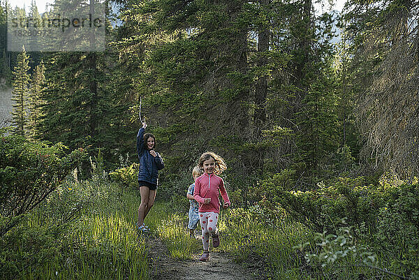 Drei Kinder laufen auf einem Pfad im Wald