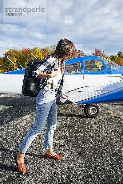 Junge BIPOC-Pilotin bei der Vorflugkontrolle in einem Kleinflugzeug