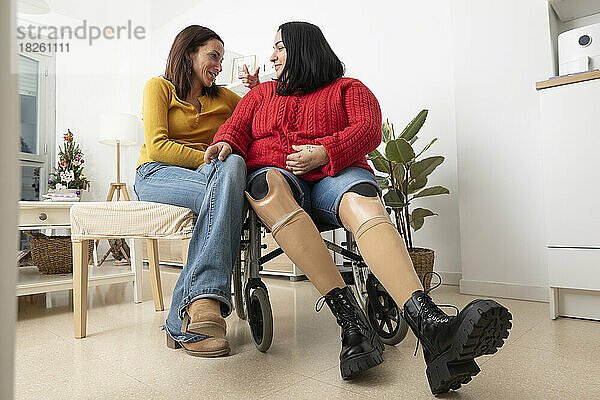 Zwei unterschiedliche Frauen unterhalten sich entspannt zu Hause.