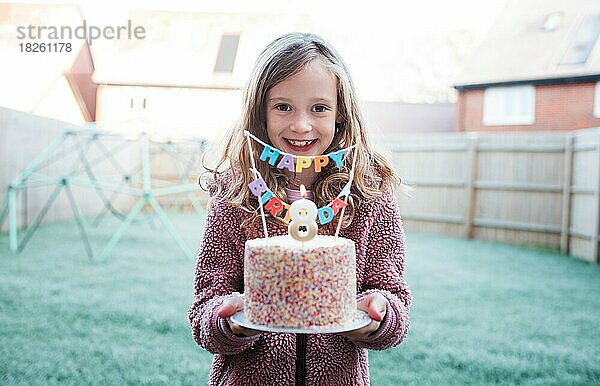 Mädchen lächelt und feiert ihren 8. Geburtstag mit einem Kuchen