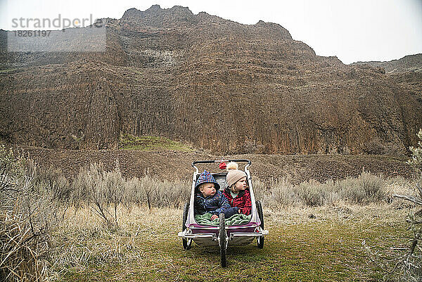 Zwei Kinder in einem Kinderwagen in einer Wüstenschlucht