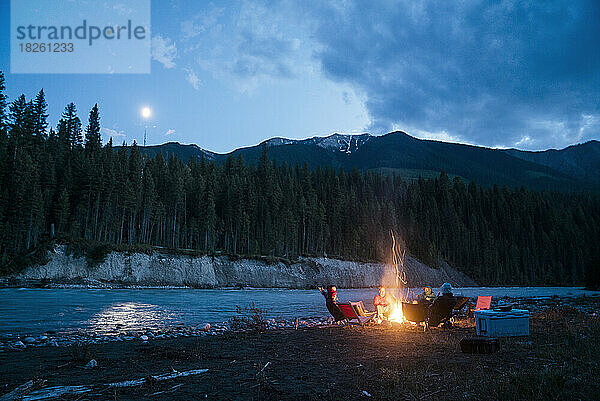 Eine Gruppe Erwachsener sitzt am Lagerfeuer am Wilderness River