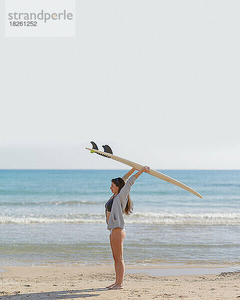 junge Frau mit Surfbrett am Strand