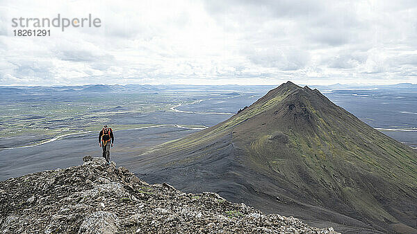 Ein Mann wandert auf einem Berg im Norden Islands