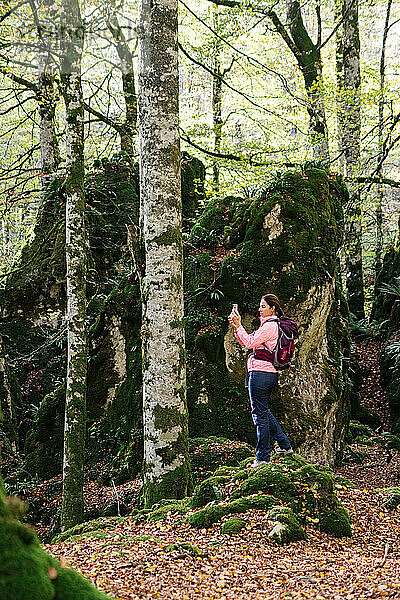 Wanderfrau fotografiert die Landschaft mit Smartphone.