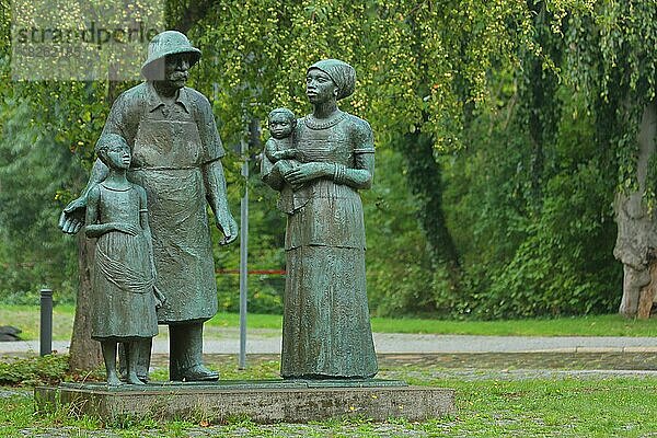 Skulptur und Denkmal an Albert Schweitzer von Gerhard Geyer  Mann  Frau  Kinder  Kleinkind  vier  tragen  Kegelplatz  Weimar  Thüringen  Deutschland  Europa