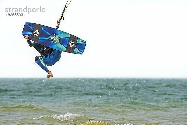 Kitesurfen mit Kiteboarder  Kitesurfer auf Twintip-Board beim Springen auf der Nordsee an einem windigen Tag