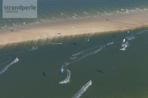 Kitesurfer  Kiteboarder  die an einem windigen Tag auf der Nordsee von Powerdrachen gezogen werden