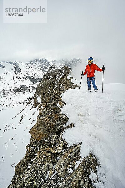 Skitourengeher am felsigen Grat mit Schnee  Obere Kräulscharte  Blick zur Inneren Sommerwand  Gletscher Sommerwandferner  wolkenverhangene Berge  Stubaier Alpen  Tirol  Österreich  Europa