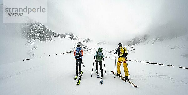 Drei Skitourengeher beim Aufstieg zum Sommerwandferner  wolkenverhangene Berge  Stubaier Alpen  Tirol  Österreich  Europa
