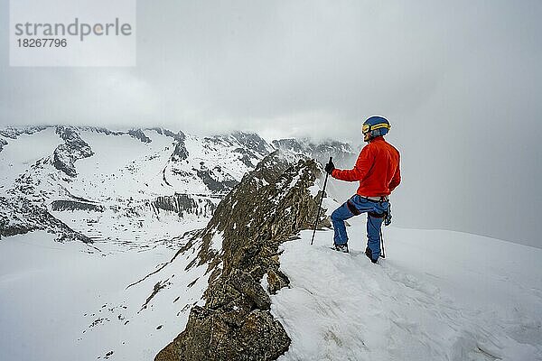 Skitourengeher am felsigen Grat mit Schnee  Obere Kräulscharte  Blick zur Inneren Sommerwand  Gletscher Sommerwandferner  wolkenverhangene Berge  Stubaier Alpen  Tirol  Österreich  Europa