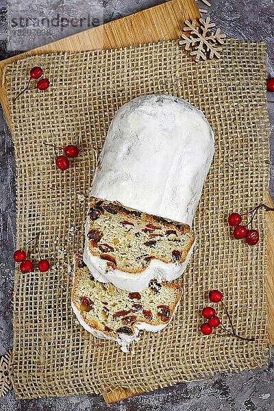 Draufsicht auf die traditionelle deutsche Weihnachtssüßspeise Stollen oder Christstollen  ein Früchtebrot mit Nüssen  Gewürzen und getrockneten oder kandierten Früchten  bestreut mit Puderzucker