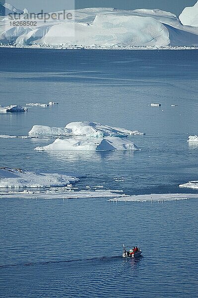 Boot vor riesigem Eisbergen und Treibeis  Fischerei  Winter  Abendstimmung  Diskobucht  Ilulissat  Arktis  Grönland  Dänemark  Nordamerika