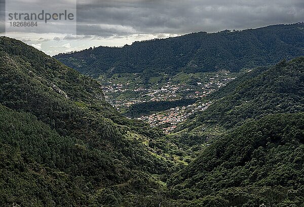 Dicht bewaldete Berge  hinten Häuser des Ortes Machico  Wanderweg Vereda do Larano  Madeira  Portugal  Europa