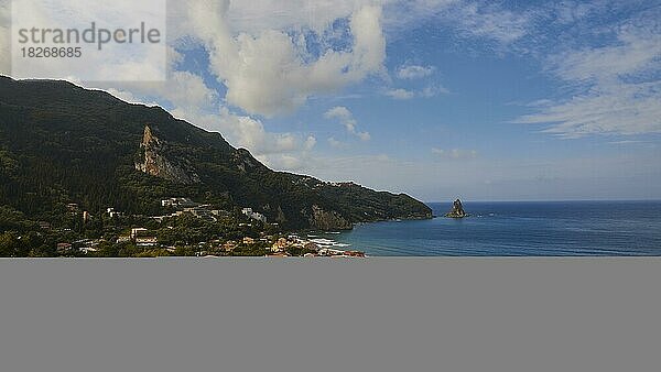 Agios Gordios  Bucht  Morgenlicht  Bäume  Häuser  Felsen im Meer  Otrholithos  blauer Himmel  wenige Wolken  blaues Meer  Insel Korfu  Ionische Inseln  Griechenland  Europa