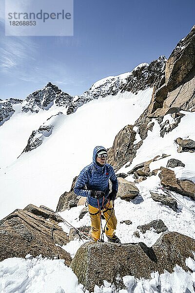 Skitourengeher bereitet Seilsicherung für Abstieg am Seil vor  Turmscharte  Ausblick auf den Gletscher Verborgen-Berg Ferner mit Gipfel Schrandele  Stubaier Alpen  Tirol  Österreich  Europa