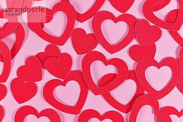 Viele herzförmige Papier Konfetti Herzen auf rosa Hintergrund