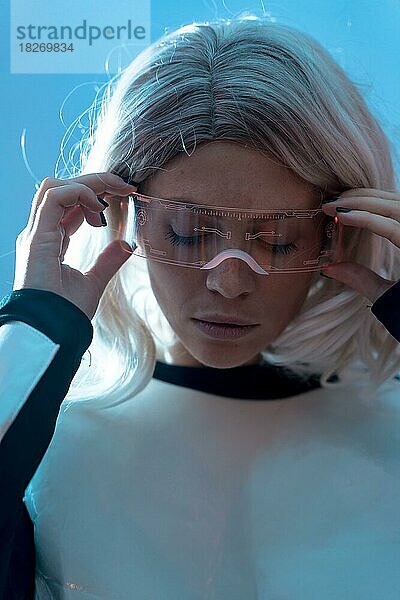 Porträt der Frau mit der futuristischen Brille  blauer Hintergrund  Zukunft und virtuelle Realität Konzept