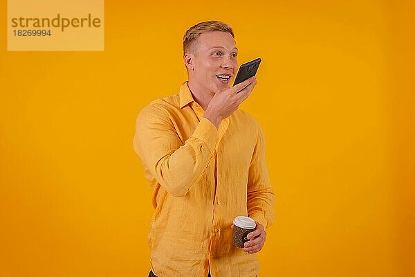 Blonde kaukasischen Mann auf einem gelben Hintergrund Senden einer Sprachnachricht lächelnd
