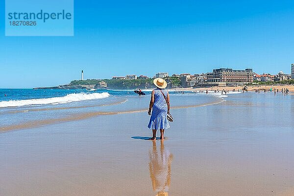 Eine ältere Frau mit Hut geht am Strand von Biarritz  Lapurdi  spazieren. Frankreich  südwestlicher Badeort