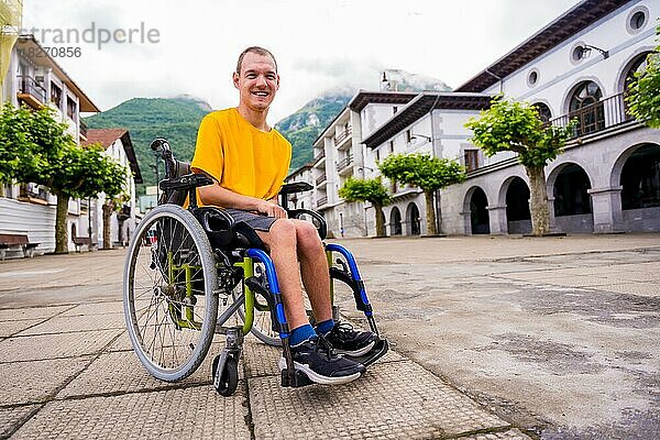 Porträt einer behinderten Person im Rollstuhl  die über den Stadtplatz geht