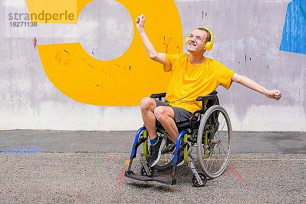 Behinderte Person im Rollstuhl hört mit Kopfhörern Musik  genießt und lächelt