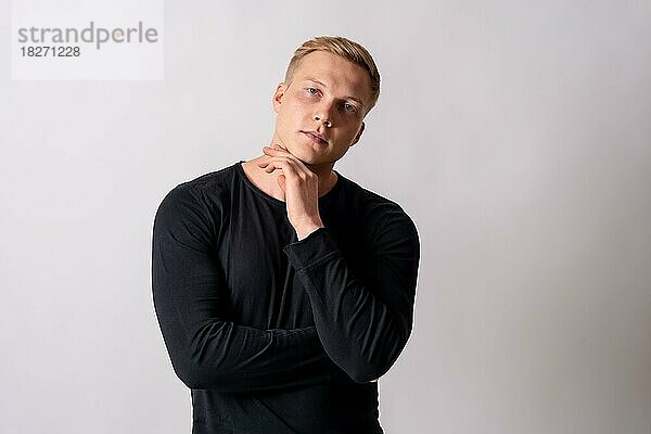 Attraktives blondes deutsches Model im schwarzen Pullover auf weißem Hintergrund  nach oben schauend mit Kopierraum