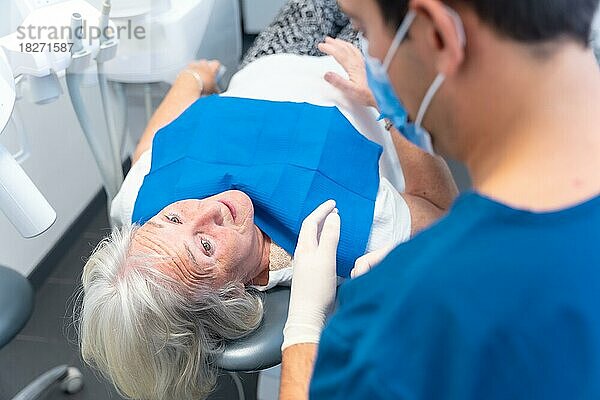 Zahnklinik  Arzt erklärt einer älteren Frau das Problem mit ihren Zähnen