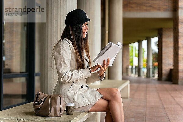 Geschäftsfrau liest lächelnd ein Buch außerhalb des Büros  Kopierraum