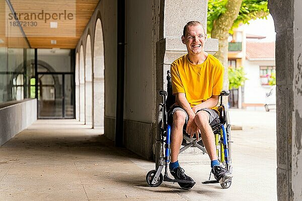 Porträt einer behinderten Person im Rollstuhl  die neben einigen Säulen in einer Tür lächelt