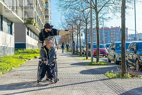 Eine behinderte Person geht mit einem Freund im Rollstuhl auf der Straße spazieren