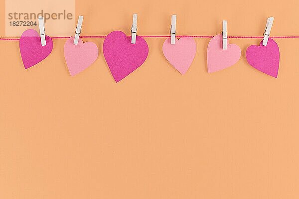Valentinstag Hintergrund mit rosa Papier Herzen hängen von Linie mit Klammern mit leeren Kopie Raum