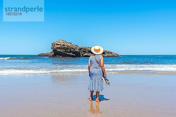 Eine ältere Frau im Urlaub schaut am Strand von Biarritz  Lapurdi  auf das Meer. Frankreich  südwestlicher Badeort