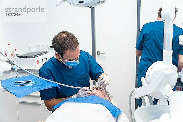 Zahnklinik  ältere Frau beim Zahnarzt  der mit dem Zahnarzt die Implantate überprüft