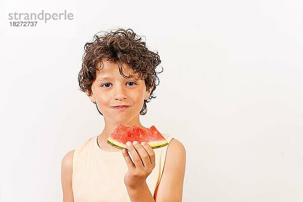 Junge genießt den Sommer und isst eine Wassermelone  Schulferien Konzept. Weißer Hintergrund