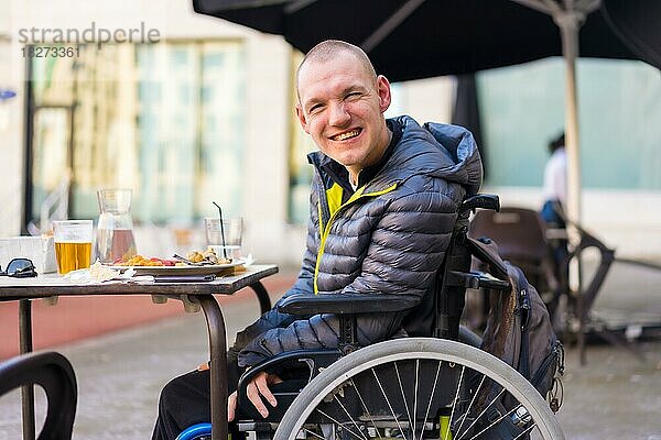 Porträt einer behinderten Person im Rollstuhl in einem Restaurant  Normalität von behinderten Menschen