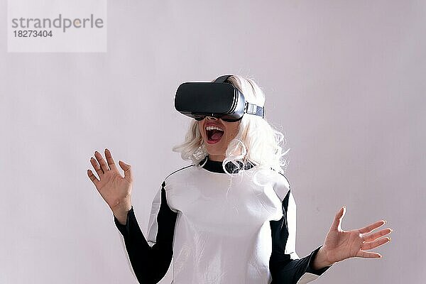 Nahaufnahme einer erwachsenen Frau  die mit einer Virtual-Reality-Brille gestikuliert  vor weißem Hintergrund
