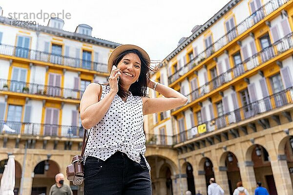 Eine Frau mit Hut  die die Stadt besichtigt und telefoniert und den Sommerurlaub genießt  Konzept einer weiblichen Reisenden und Schöpferin digitaler Inhalte