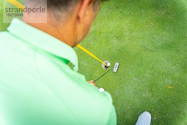 Mann beim Golfspiel  Detail eines Schlags mit dem Putter auf dem Grün  Ansicht von oben