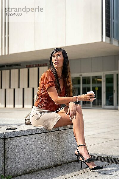 Porträt einer Geschäftsfrau außerhalb des Büros mit einem Kaffee in der Hand