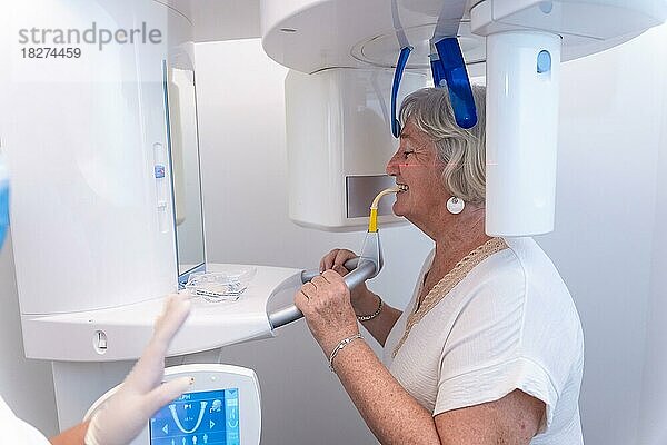Zahnklinik  ältere Frau im Röntgenraum  die eine Röntgenaufnahme macht