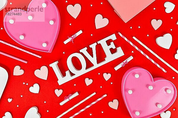Valentinstag Dekoration mit Liebe Text  Herz Ornamente und Streusel auf rotem Hintergrund