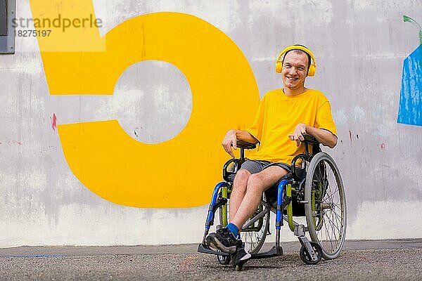 Porträt einer gelb gekleideten behinderten Person in einem Rollstuhl  die lächelnd Musik hört