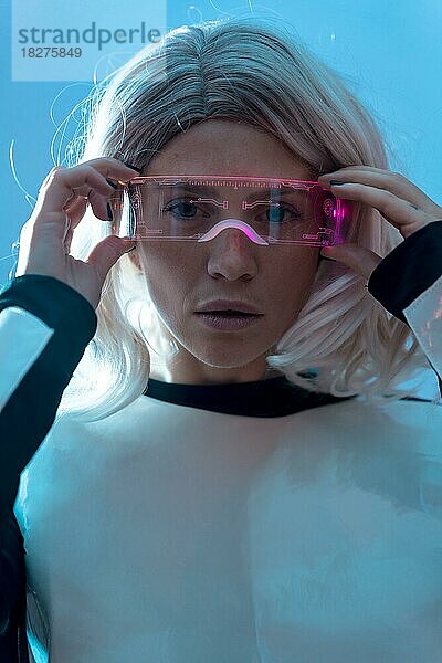 Porträt einer Frau mit einer futuristischen Brille  blauer Hintergrund  Zukunft und Virtual-Reality-Konzept
