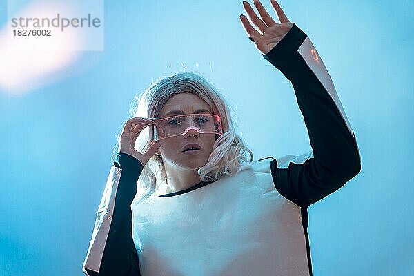 Schöne Frau mit der futuristischen Brille  blauer Hintergrund  Zukunft und virtuelle Realität Konzept