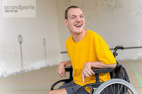 Porträt einer behinderten Person im Rollstuhl bei einem baskischen Pelota-Spiel fronton lächelnd