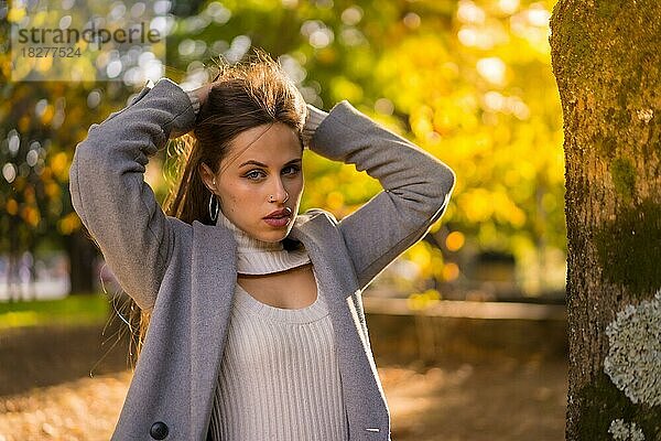 Hübsche Frau genießt den Herbst in einem Park bei Sonnenuntergang  copy paste space