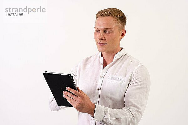 Kaukasischer Geschäftsmann mit einem Tablet  der auf einem weißen Hintergrund arbeitet