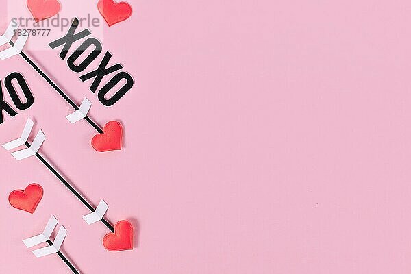 Valentinstag flach legen mit Amors Liebe Pfeile und Text XOXO auf rosa Hintergrund mit Kopie Raum
