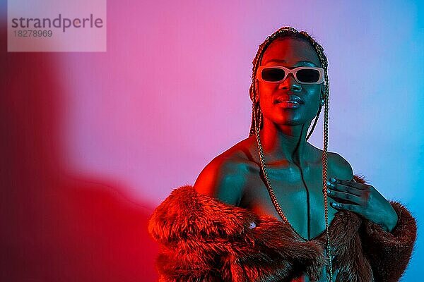 Attraktive schwarze Frau mit Zöpfen mit roten und blauen LED-Lichter  Studio schießen